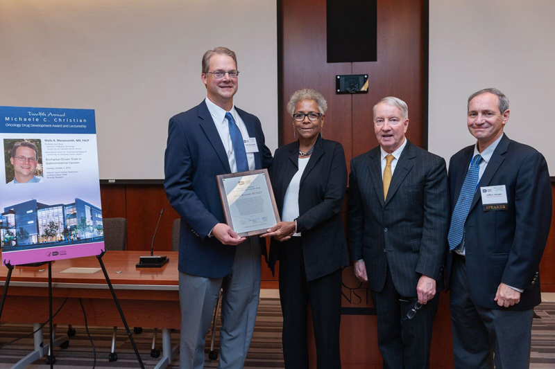 Michaele Christian, MD presents the award to Wells Messersmith, MD. L to R: Wells Messersmith, Michaele Christian, John Wright, Jeff Abrams