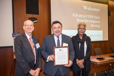 Jeff Moscow (L) and Michaele Christian (R) present the award to Timothy Yap.