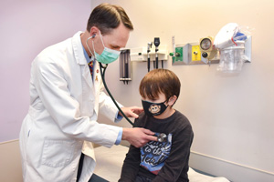 Dr. Matthew Kutny of Children’s of Alabama and the University of Alabama at Birmingham examines Asher, who participated in the Children’s Oncology Group trial that tested all-trans retinoic acid and arsenic trioxide for acute promyelocytic leukemia.
