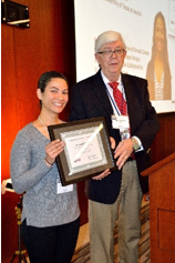 Image of Angela Jarrett, PhD, University of Texas at Austin, receives the QIN Larry Clarke Young Investigator Award from Robert Nordstrom, PhD, NCI, at the 10th QIN Annual Meeting