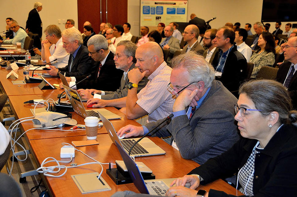 Members of the Quantitative Imaging Network sit at desks while attending the network’s annual meeting.