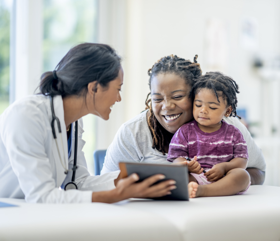 Clinical researcher shows a tablet to a happy parent and child