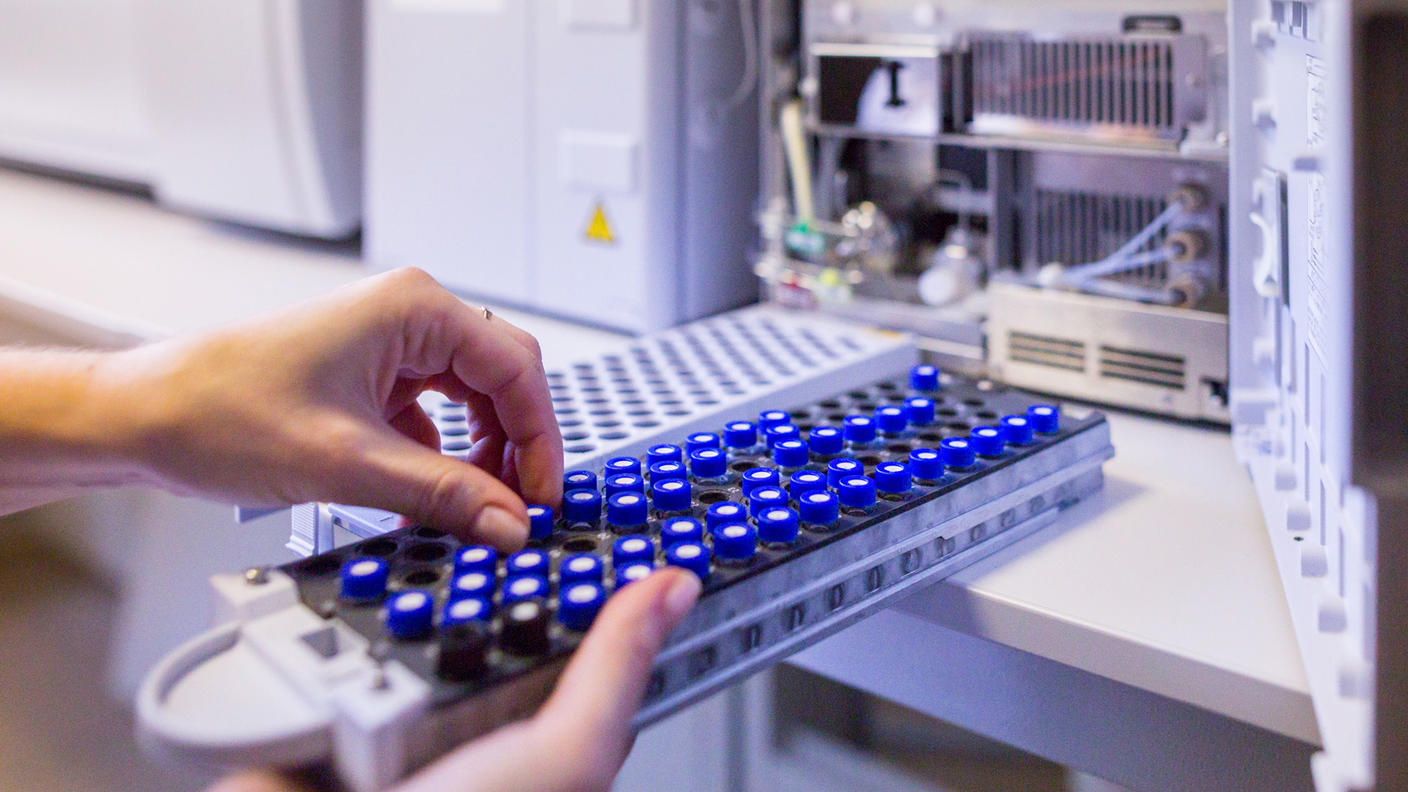 scientist handling sample vials.
