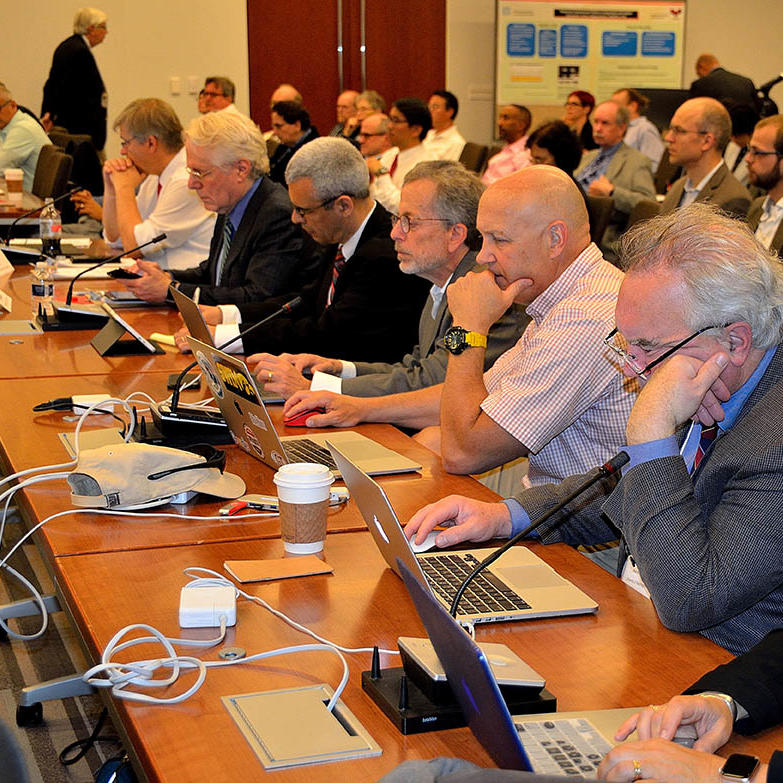 Members of the Quantitative Imaging Network sit at desks while attending the network’s annual meeting.