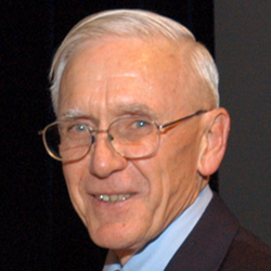 Headshot of Dr. Gordon Cragg wearing a suite with red tie